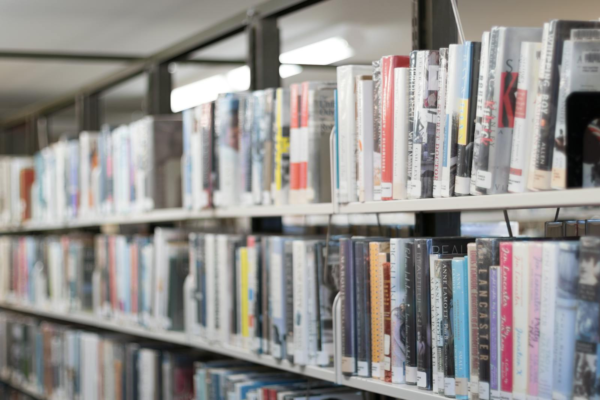 Rows of colorful books on shelves in a well-lit library in West Hartford, CT.