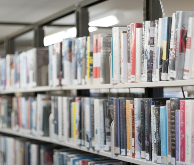 Rows of colorful books on shelves in a well-lit library in West Hartford, CT.