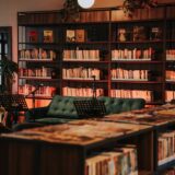 A warm and inviting library interior with bookshelves and a comfortable green couch.