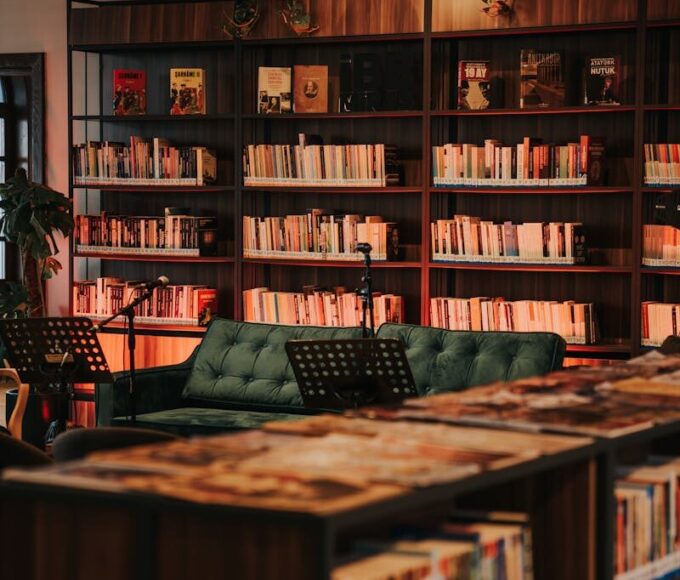 A warm and inviting library interior with bookshelves and a comfortable green couch.