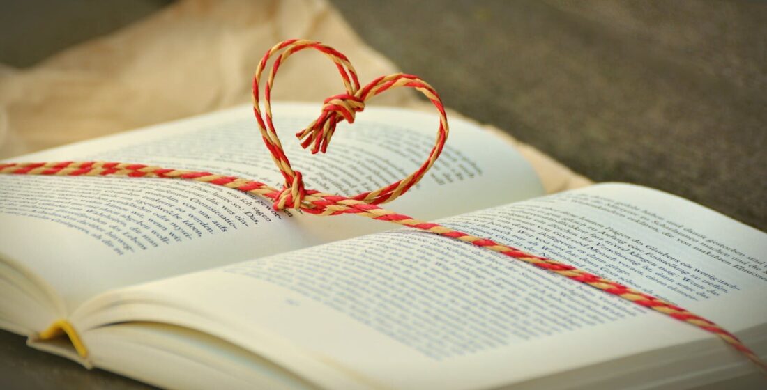 Open book with a heart-shaped string bookmark, symbolizing love for reading.