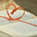 Open book with a heart-shaped string bookmark, symbolizing love for reading.