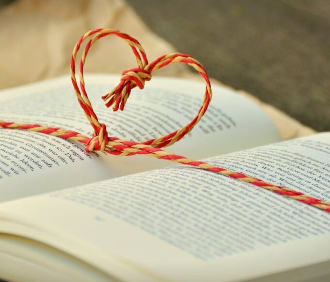 Open book with a heart-shaped string bookmark, symbolizing love for reading.