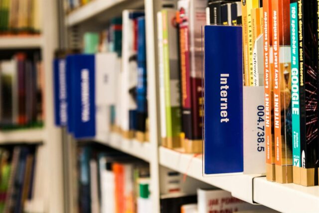 Close-up of a library shelf with books on internet and technology. Ideal for education-themed projects.