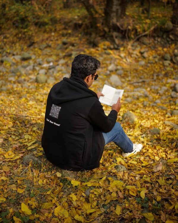 A man reading a book on fallen autumn leaves in New Theed, Kashmir.