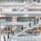 Spacious and minimalist design of the Stuttgart City Library showcasing multiple levels of books and people.