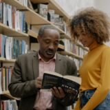 A man and a woman studying together in a modern library setting, focusing on learning and education.