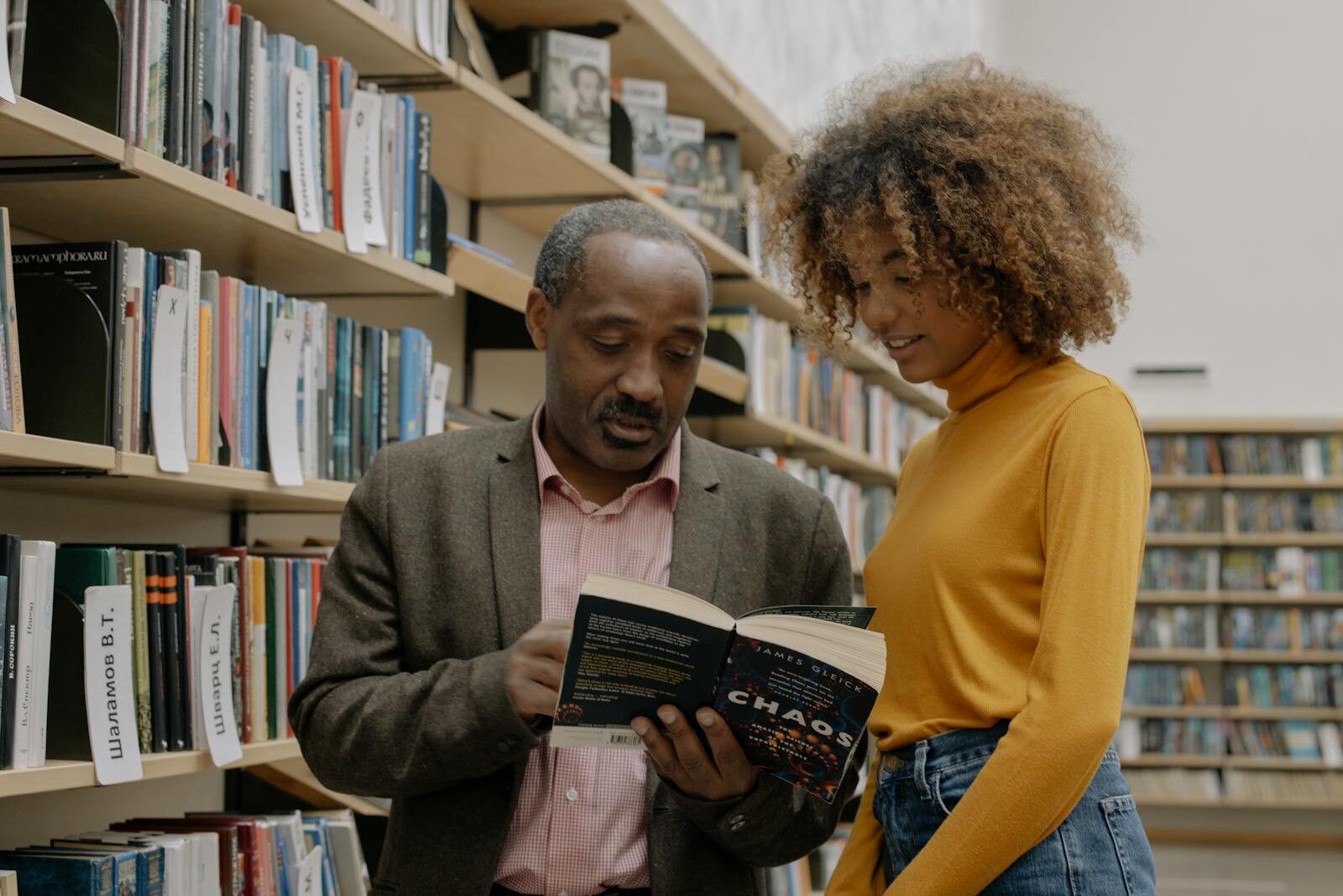 A man and a woman studying together in a modern library setting, focusing on learning and education.