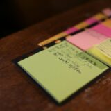 green sticky note on brown surface