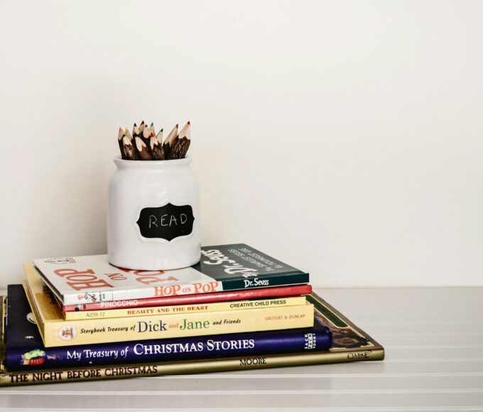 white ceramic pencil organizer on top of stack of books