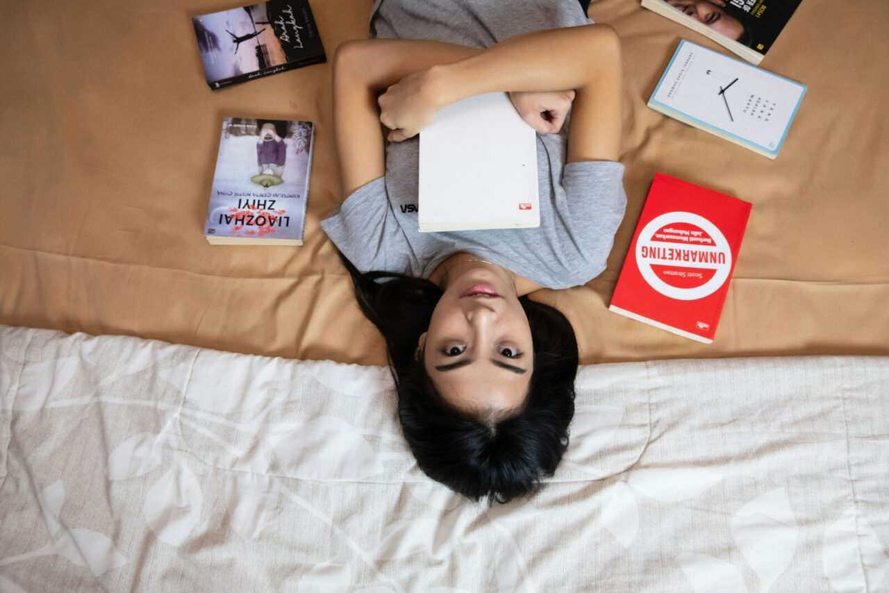 woman in gray shirt lying on bed