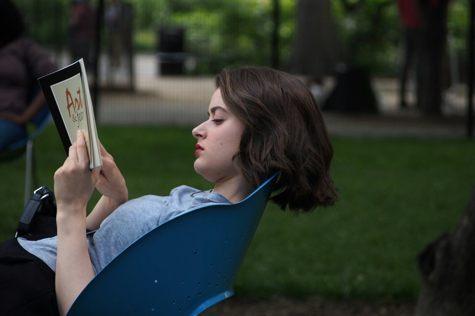 a woman sitting in a chair reading a book