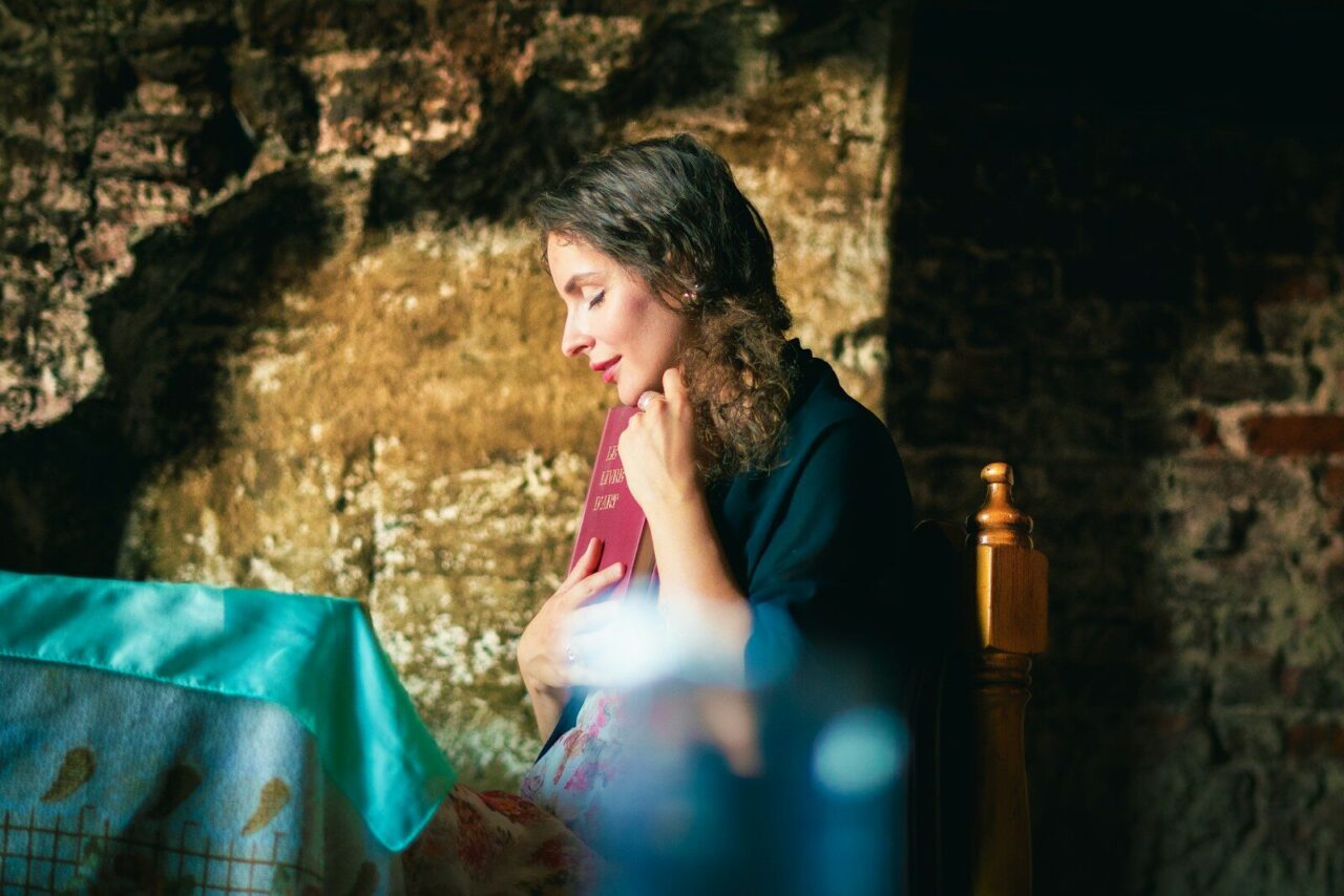 A woman sitting at a table looking at a laptop