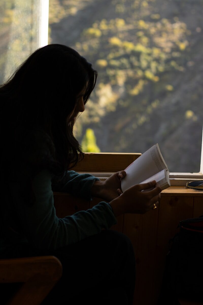 A woman sitting in a chair reading a book